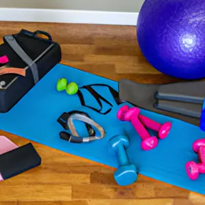 An image showcasing a neatly organized home gym setup, complete with exercise equipment, weights, yoga mats, and resistance bands, all arranged within a limited budget